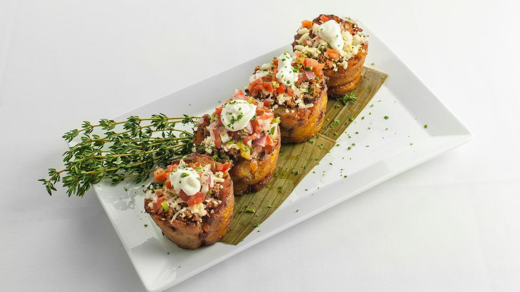Piononitos · Puerto Rican timbales of sweet plantains, ground beef, and cheese topped with pico de gallo and sour cream.