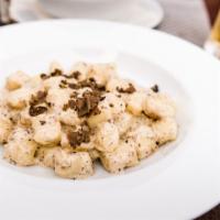 The Truffle Gnocchi · Parmesan cheese, basil, truffle paste, and fresh alfredo sauce sitting on a bed of gnocchi.