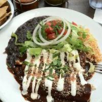 Enchiladas De Mole With Chicken · Tortillas filled with chicken in red mole sauce topped with lettuce, onions, tomatoes, chees...