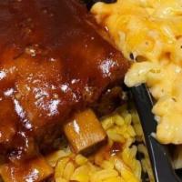 Bbq Ribs Soul Platter  · Slow Cooked BBQ Pork Ribs served over Seasoned Yellow Rice with a side of Candied Yams and B...