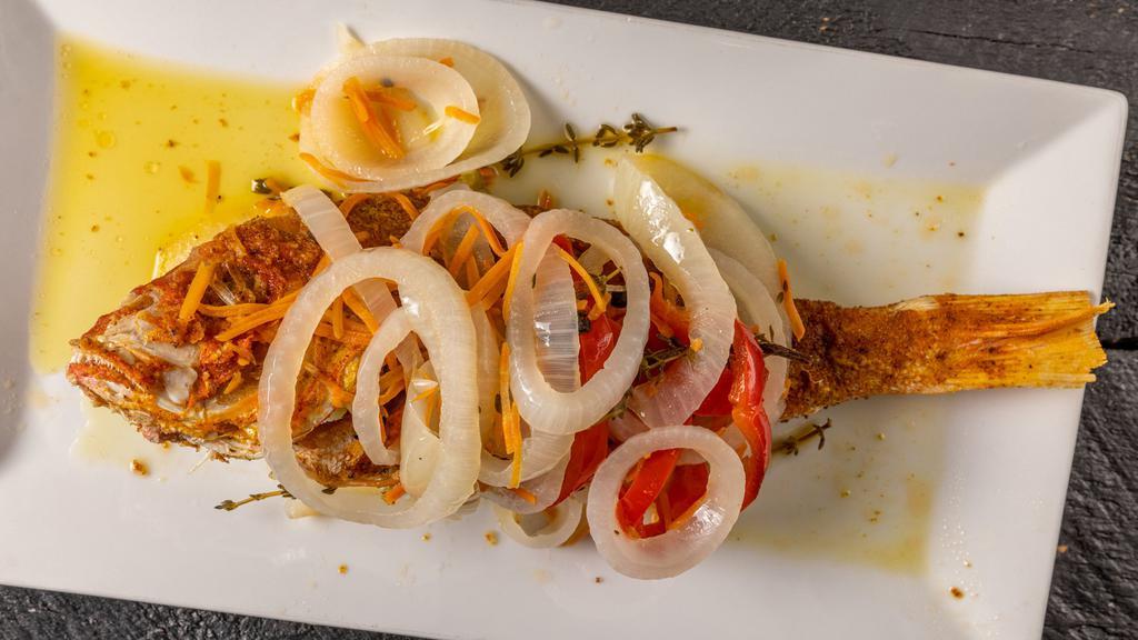 Escoviche Red Snapper · Seasoned whole snapper fried and garnished with a vinegar sauce of hot peppers, onions, carrots, and vegetables.