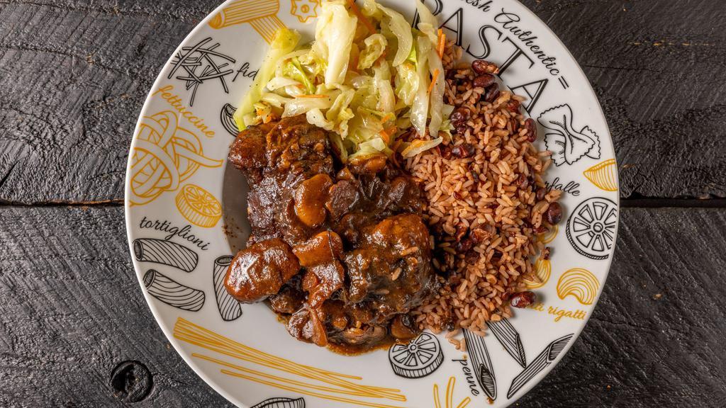 Savory Oxtails · Oxtail seasoned, pan braised and cooked until tender in a brown stew with butter beans and carrots.
