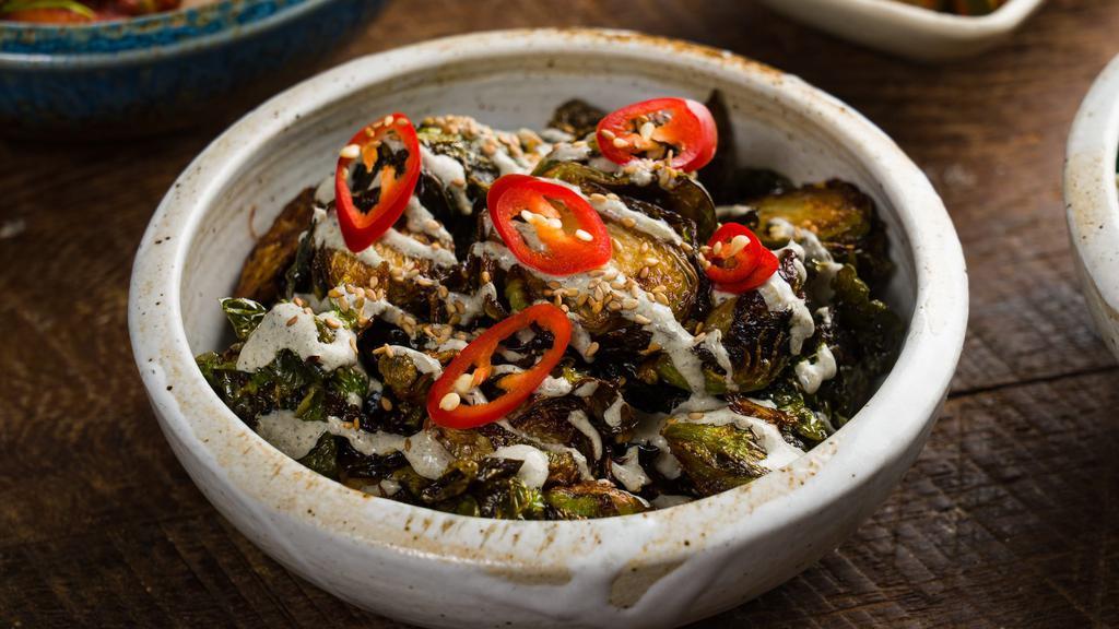 Brussels Sprouts · Crispy brussels tossed in a sweet soy glaze and drizzled with charred scallion sour cream.