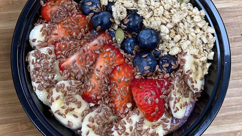 Power Acai Bowl · Blended organic acai, strawberries, blueberries, chocolate protein and almond milk, topped with banana, granola, natural peanut butter, honey and sprinkled flax seeds.