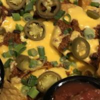 Nachos · Warm corn tortilla chips topped with cheese sauce, green scallions and jalapeños served with...