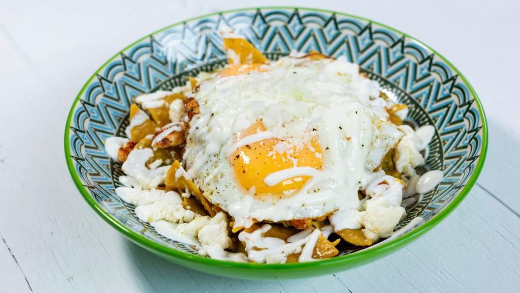 Chilaquiles · Fried tortilla chips cooked in salsa verde, topped with queso fresco, crema fresca and sunny side up egg.