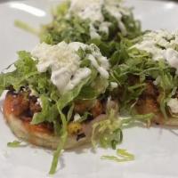 Sope · Homemade corn tortillas, topped with beans, choice of protein, lettuce, tomato, sour cream a...