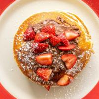 Nutella Stacker · Four pancakes layered with Nutella, pecans, and fresh strawberries.