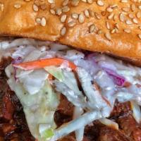 Sliced Brisket Sandwich · chopped brisket in sauce topped with cole slaw on a toasted sesame brioche bun