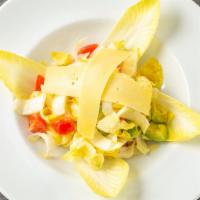 Indivia · Endive, cherry tomatoes, avocado, Parmigiano cheese flakes, and a lemon dressing.