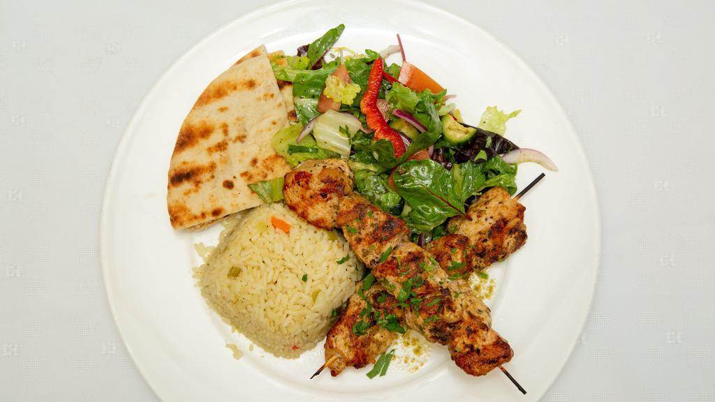 Chicken Souvlaki · Marinated cubes of delicious grilled chicken on a skewer with rice pilaf  pita bread and small salad.