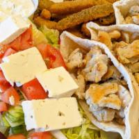 Souvlaki · Marinated cubes of pork or chicken, with tzatziki sauce, plated with small Greek salad.