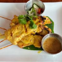 Chicken Satay · Marinated chicken on a skewer served with peanut sauce and cucumber radish.