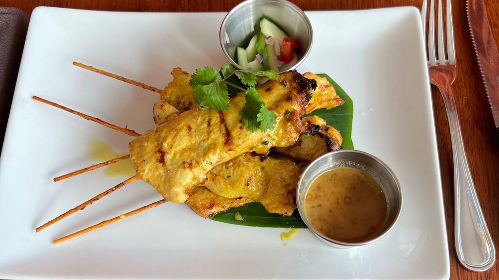 Chicken Satay · Marinated chicken on a skewer served with peanut sauce and cucumber radish.