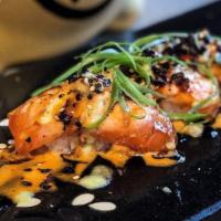 Salmon Osaka (4 Pieces) · Seared fresh salmon nigiri with Kewpie, eel sauce spices and fried garlic. AMAZING!