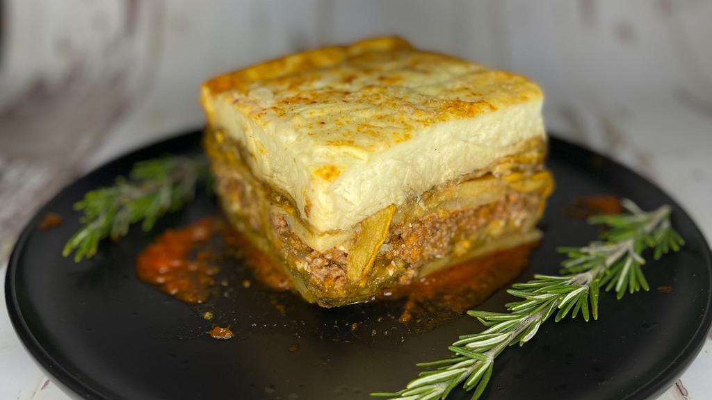 Mousaka · Baked layers of eggplant, potato, ground beef, and pork with béchamel sauce, served with soup or salad.