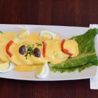 Papa A La Huancaina · Sliced boiled potatoes topped with a creamy yellow sauce.