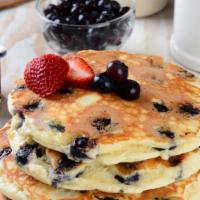 Blueberry Pancakes · A stack of 3 fluffy pancakes topped with locally grown blueberries then dusted with powdered...