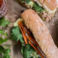 Traditional Pork Paté Banh Mi Sandwich · Traditional cured pork hock sliced sausage with a spread of pate on a hot toasted French bag...