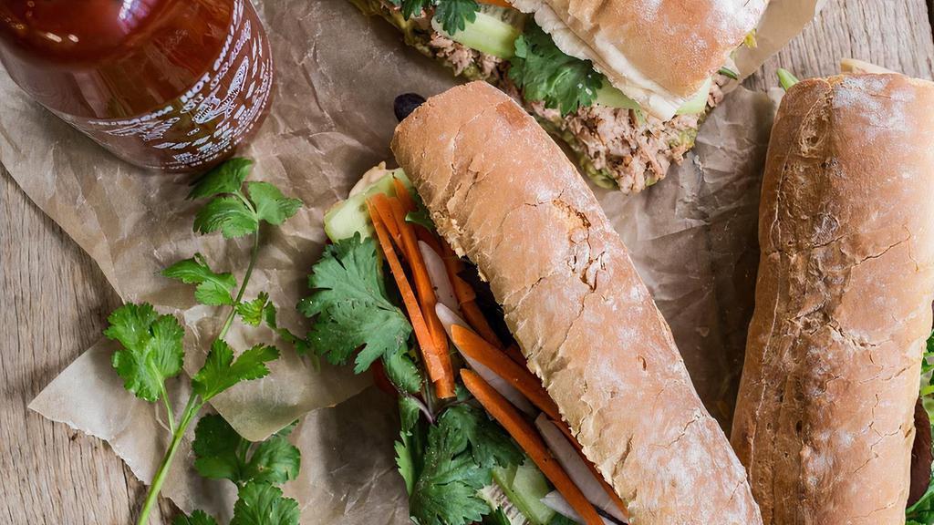 Traditional Pork Paté Banh Mi Sandwich · Traditional cured pork sausages sliced pork meatloaf with a spread of pate on a hot toasted French baguette, light spread of mayo, cilantro, pickled carrots, cucumbers, sliced jalapeño pepper and a dash of black pepper.