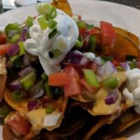 Irish Nachos · Homemade potato chips smothered in Guinness cheese sauce with sour cream, scallions and chop...