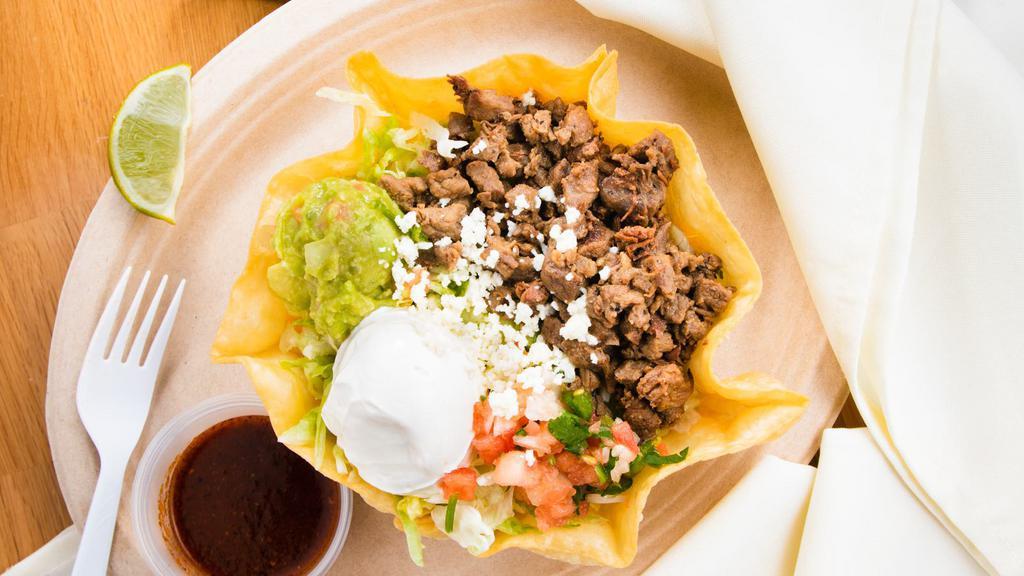 Taco Salad · Crispy flour tortilla shell filled with beans, lettuce, pico de gallo, guacamole, and sour cream. With your choice of shredded beef, shredded chicken, carne asada, or pork carnitas. Topped with cilantro or Ranch dressing.