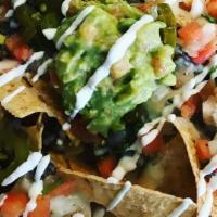 Nachos · Loaded with beans, choice of meat, cheese, pico de gallo, jalapenos, guacamole, and sour cre...