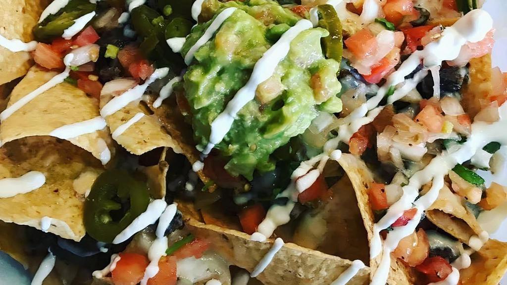 Nachos · Loaded with beans, choice of meat, cheese, pico de gallo, jalapenos, guacamole, and sour cream.