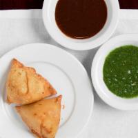 Vegetable Samosa · 2pc of deep-fried triangular shape patties stuffed with potatoes, green peas, and spices.