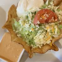 Taco Salad · Fried tortilla shell filled with ground beef or chicken, beans, cheese sauce and topped with...