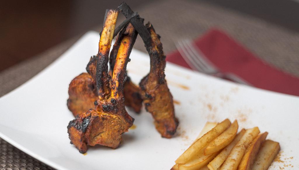 Lamb Chops · Rack of lamb marinated in aromatic Indian herb fresh ginger juice rum, and yogurt. Served with fries.