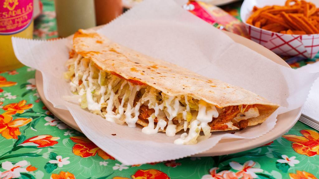 Quesadilla De Flor De Calabaza · Vegetarian. Quesadilla filled with squash blossoms. Served with queso Oaxaca, lettuce, sour cream and queso Cotija.