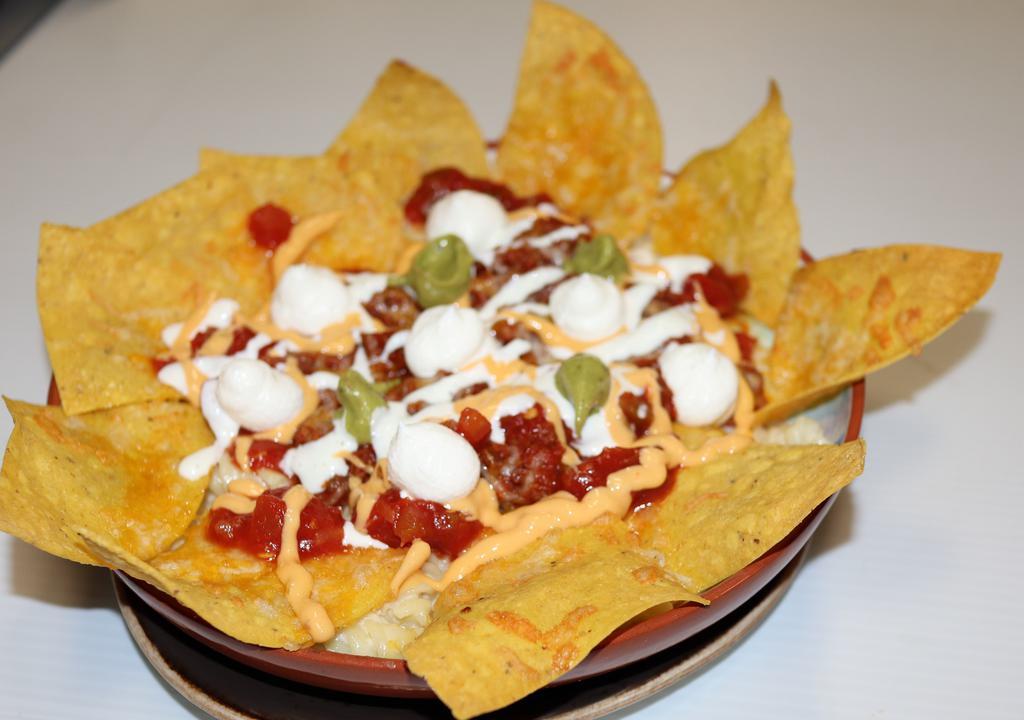 Nacho Pasta · (Rotini pasta tossed in creamy cheese sauce topped with ground beef, cheese, salsa, sour cream, guacamole, and crispy corn tortilla chips).