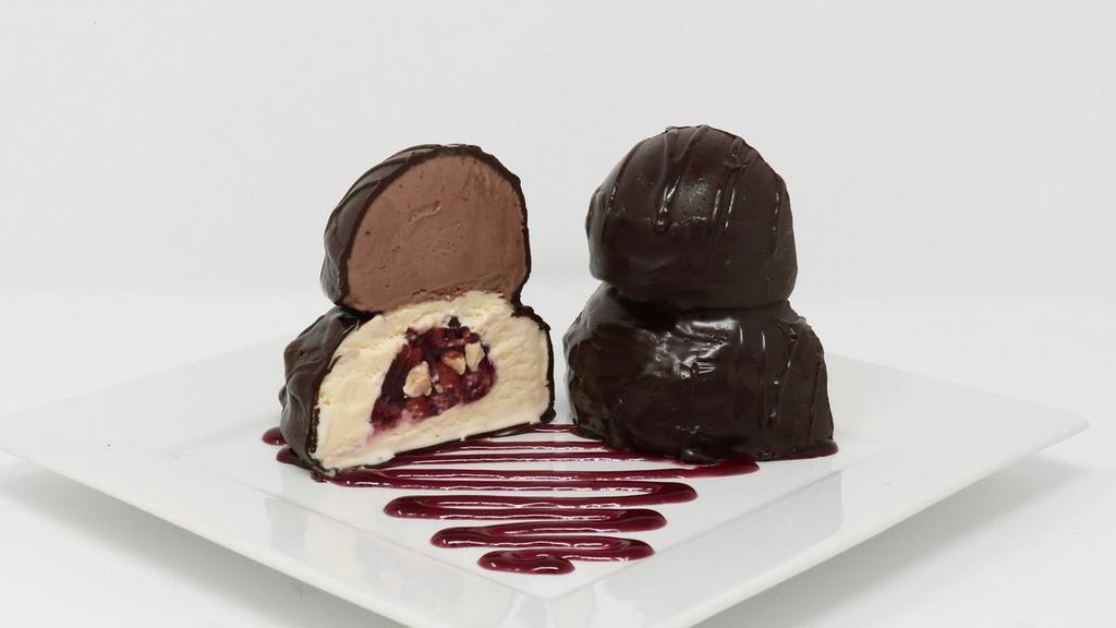 Coco Tartufo · A double decker Ice cream Truffle, vanilla and chocolate ice cream with a raspberry and almond center, enrobed in dark chocolate.