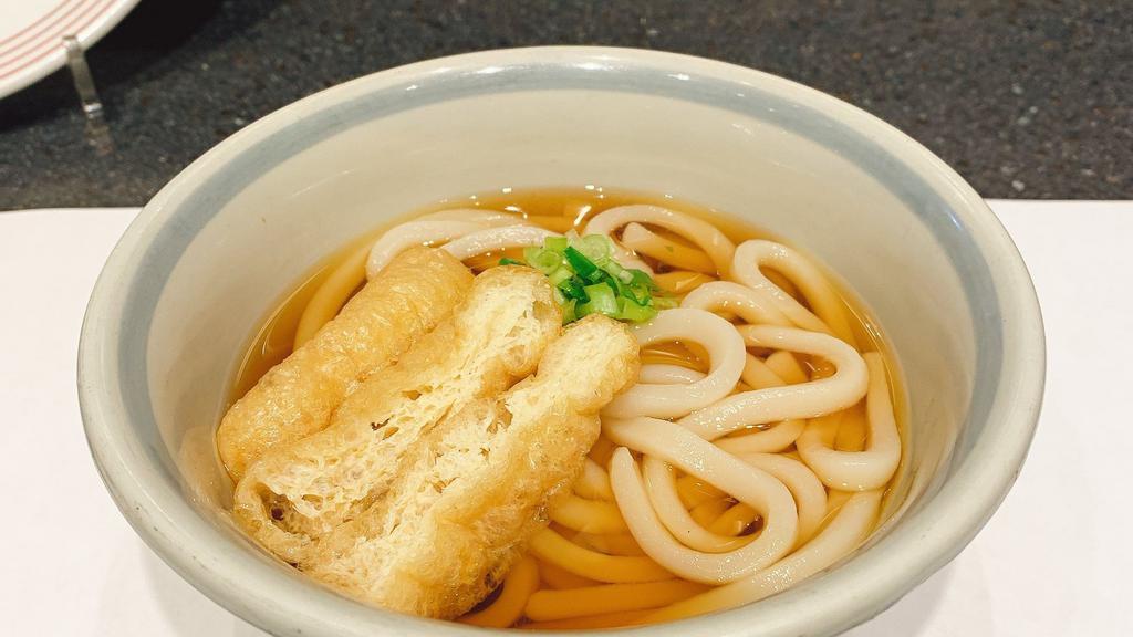 Kake Udon · Udon noodle in mildly flavoured dashi broth topped with deep fried thin tofu and chopped green onions.