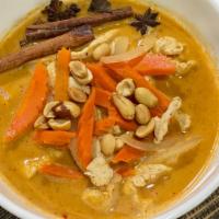 Massaman Curry · Rich brown creamy coconut milk curry with potatoes, onion, peanut, and carrot.