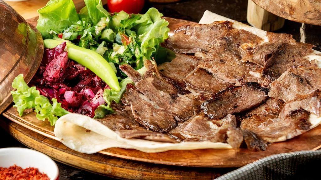 Lamb Gyro Plate Small · Doner kebab is a type of Turkish kebab, made of meat cooked on a vertical rotisserie. Seasoned meat stacked in the shape of an inverted cone is turned slowly on the rotisserie, next to a vertical cooking element.