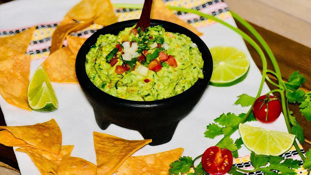 Homemade Guacamole With Nachos ( Chips )  · Guacamole made from the scratch, mixed with diced union, diced tomatoes, cilantro, lime and a bit of salt..