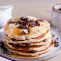 Chocolate Chip Buttermilk Pancakes · Three perfectly fluffy chocolate chip pancakes served with a side of butter and syrup.