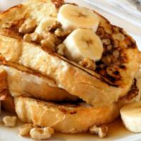 Banana French Toast · Sliced challah bread soaked in eggs and milk, then fried and topped with bananas served with...