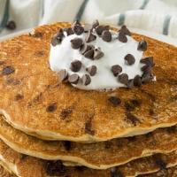 Chocolate Chip Pancakes · Five stack of pancakes with chocolate chips and chocolate sauce.
