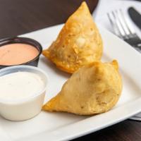 Vegetable Samosa · Two pieces. Fried flaky, handmade pastries stuffed with curried potatoes and green peas. Ser...
