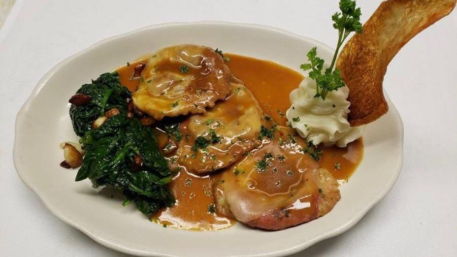 Saltimbocca · Veal scalloppini with prosciutto sage sauce served on a bed of spinach.
