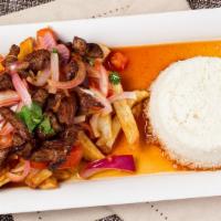 Lomo Saltado · Sliced steak with onions and tomatoes served on top of fries, with white rice.
