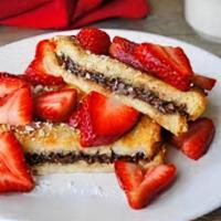 Stuffed Nutella French Toast · Three slices French toast stuffed with Nutella® and topped with sliced strawberries.