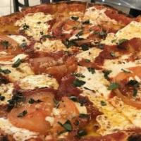 Margherita Pizza · Olive Oil, thinly sliced Fresh Tomato, Fresh Mozzarella, Tomato Sauce & Fresh Basil