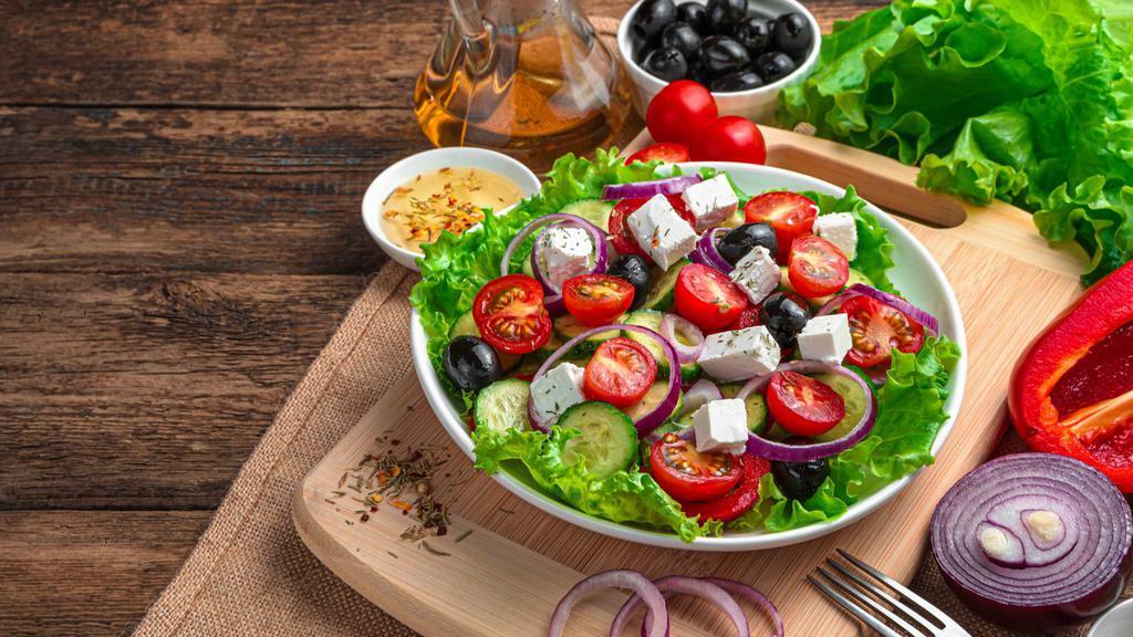 Greek Salad · Fresh salad made with romaine lettuce, feta cheese, stuffed grape leaves, tomatoes, red onions, Kalamata olives, cucumbers, and bell peppers.