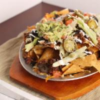 Vegetarian Nachos · Tortilla chips covered in melted cheese, mix of vegetable, topped with tomatoes, lettuce, on...