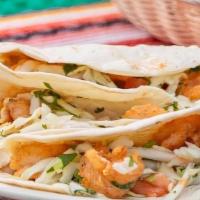 Fish Tacos Lunch · 2 tacos made with cornmeal crusted tilapia topped with chipotle ranch dressing and shredded ...