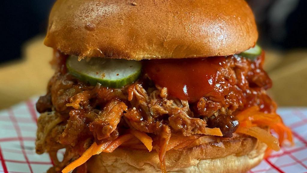 Pulled Pork Sandwich · Twelve  hour smoked pork shoulder, tossed in our bible belt BBQ sauce. Served with pickled carrot and radish slaw, hot house pickles, all on grilled brioche.